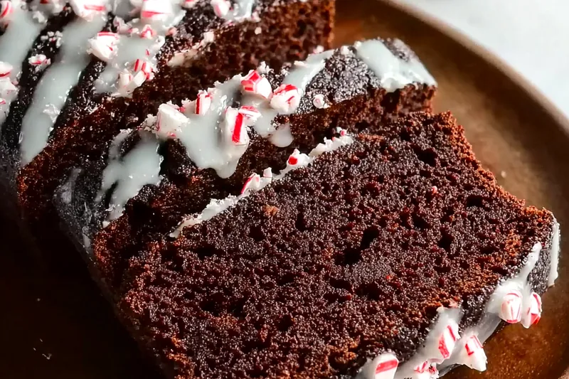 Cocoa powder, chocolate chips, peppermint candies, flour, eggs, buttermilk, and other baking ingredients arranged on a marble countertop